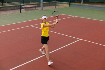 Professional equipped female tennis player beating hard the tennis ball with racquet.