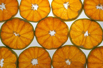 Tangerine slices in backlight. Citrus pattern background.
