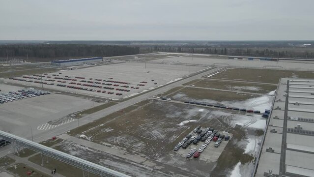 The new cars are lined up in the parking lot outside the production facility.