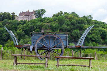 Vieille charrette devant un château entouré de végétation dans le département de la Dordogne dans le sud-oust de la France