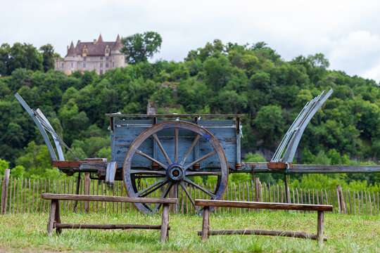 Vieille charrette devant un ch&acirc;teau entour&eacute; de v&eacute;g&eacute;tation dans le d&eacute;partement de la Dordogne dans le sud-oust de la France