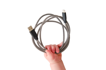 Baby toddler boy holds a usb cable in his hand to charge his phone, isolated on a white background. Child with a wire in his hands, close-up