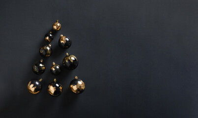 Banner with modern Christmas Tree made of golden and black balls on black background. Decorative...