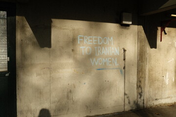 a wall with a slogen that supporting iranian women's fight - obrazy, fototapety, plakaty