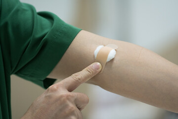 Close up patient hand push cotton after taking blood sample from a patient in the hospital.Nurse...