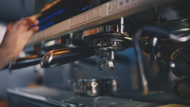 Closeup of barista installing basket into espresso machine, coffee shop job