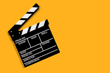 Fototapeta na wymiar Movie clapperboard for shooting videos and movies on a orange background copy space