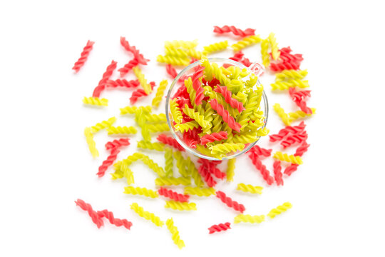 Close-up background of Fusille and Rotini in a glass bowl on white. pasta colorata	