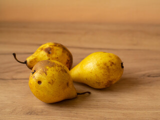 Three juicy yellow pears on a wooden table