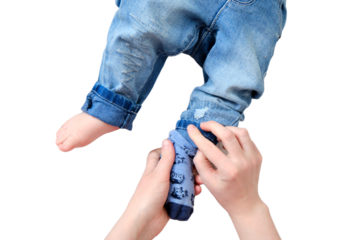 A mother woman wears blue socks to a foot baby boy, isolated on a white background. Mom dresses a leg child in clothes. Kid nine months old