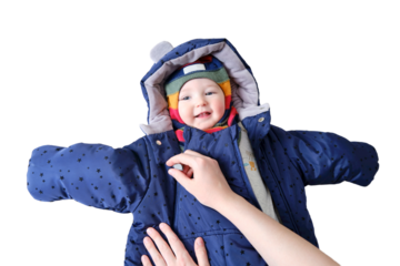 A mother woman puts on a warm jacket for a baby boy, isolated on a white background. Mom dresses a happy child in winter clothes. Kid nine months old