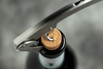 Bottle, corkscrew and cork on a black background. Close-up. Selective focus.