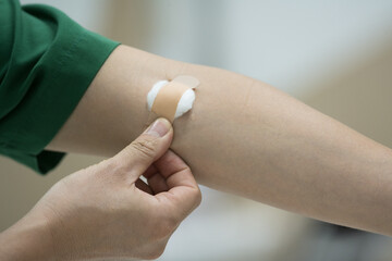 Close up patient hand push cotton after taking blood sample from a patient in the hospital.Nurse...