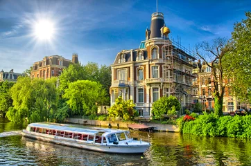 Deurstickers Boat on Amstel river near beautiful houses in Amsterdam, Holland © Eagle2308