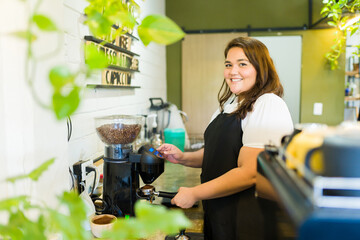 Happy barista using the coffee machine