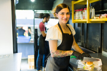 Portrait of a smiling woman chef working at the food truck - obrazy, fototapety, plakaty