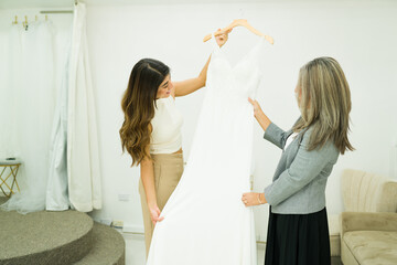 Beautiful woman with her mom buying a wedding gown