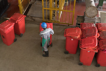 Workers sort infected bins for destruction in a waste disposal facility.Big red garbage jugs on the center waste at the hospital.Infection control concept