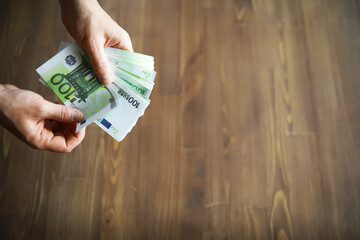 European Union banknotes in hands. A pack of 100 euro banknotes in the hands. Recalculation of cash.