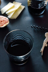 red wine and cheese on dark table