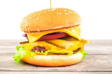 A toasted sesame bun hamburger with pickles and ripe tomatoes