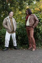 Fototapeta premium lifestyle image of transgender nonbinary friends talking in the park
