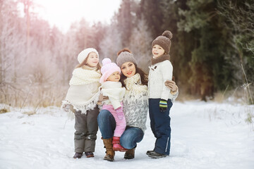 Obraz premium Happy family playing and laughing in winter outdoors in the snow. City park winter day.