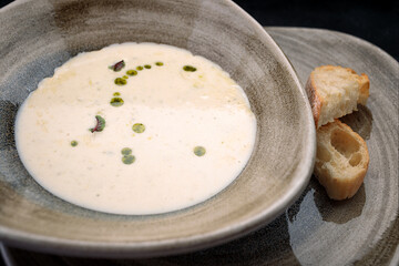 Mushroom cream soup with homemade bread, on dark concrete