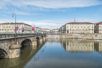 Obraz premium The murazzi and the Vittorio Emanuele bridge of Turin are reflected in the water of the river Po