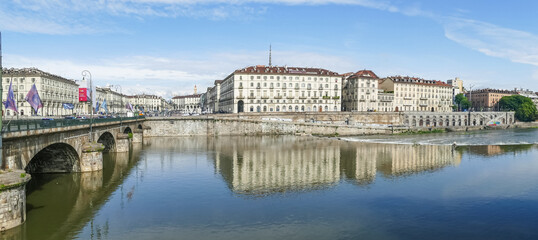 Fototapeta na wymiar The murazzi and the Vittorio Emanuele bridge of Turin are reflected in the water of the river Po
