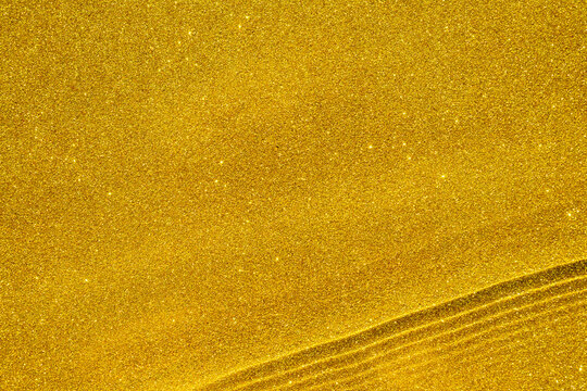 Abstract golden glitter texture with waves and ripples, sparkling background