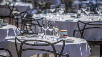Tables d'un restaurant avec des nappes blanches en tissu et des verres en cristal à Monaco