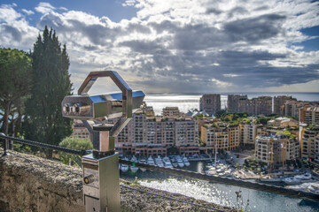 Fototapeta na wymiar Panorama sur le quartier de Fontvieille à Monaco, construit sur un polder au pied du rocher avec une paire de jumelles de vue au premier plan