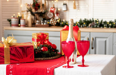 Red wine glasses and a bottle of champagne on the festive table at home. Christmas concept, New Year celebration