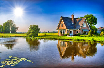 Fototapeta na wymiar Red bricks house in countryside near the lake with mirror reflec