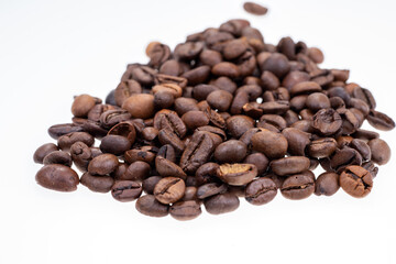 Heap of dry coffee beans isolated on white background