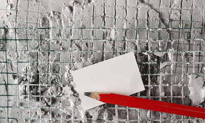 Wet cement reinforcement with wire mesh and red construction pencil, paper background and texture