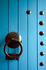 Detalle de una puerta de madera pintada de azul turquesa