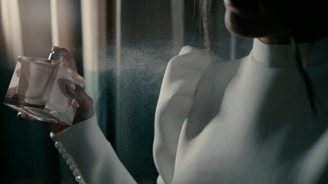 A bride puts perfume in the dressing room before the start of the wedding day. Slow motion video close-up of the bride with perfume. perfume foe a bride