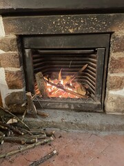 Chimenea y hoguera de leña encendida y con llama avivada calentando un hogar.