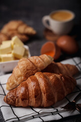 delicious croissants on parchment on a dark concrete background,coppy space.