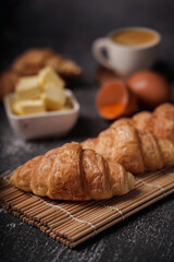 delicious croissants on parchment on a dark concrete background,coppy space.