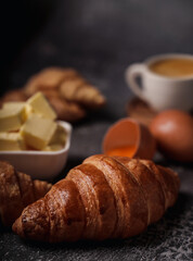 delicious croissants on parchment on a dark concrete background,coppy space.