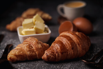 delicious croissants on parchment on a dark concrete background,coppy space.