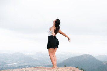 scantily clad caucasian mature woman taking a big breath with arms back and head raised
