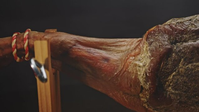 Jamon on a wooden stand in smoke.