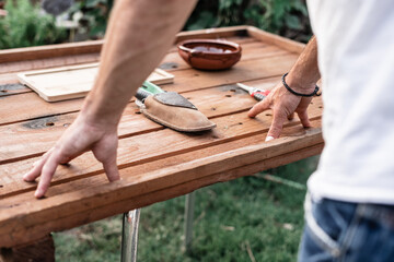 hands of caucasian young man next to pruning shears on a wooden table