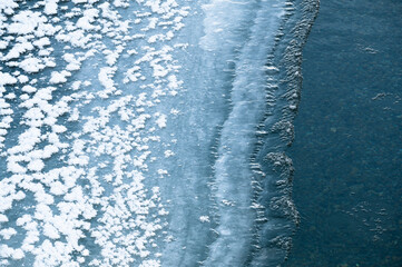 Ice formations on side of river in winter