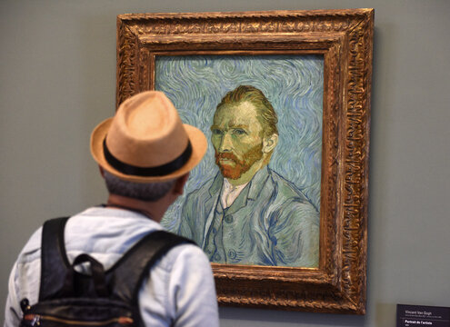Paris, France - August 29, 2019: Visitor near the Self-Portrait by Vincent van Gogh painting in Museum d'Orsay in Paris, France.
