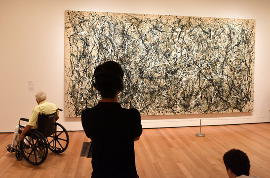 New York, USA - May 25, 2018: A visitors looks at the Jackson Pollock painting in Museum of Modern Art in New York City.